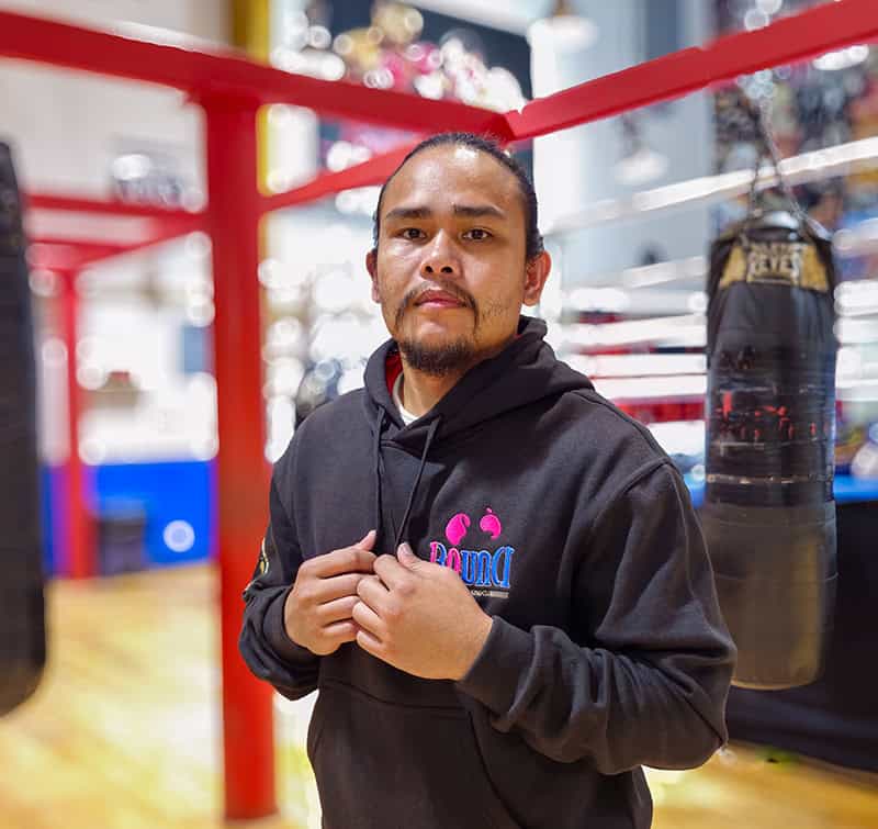 Standing amidst the iconic setting of our premier boxing gym in Dubai, a dedicated athlete dons a sleek black hoodie. The atmosphere is charged with intensity as punching bags hang purposefully around and the commanding presence of the boxing ring looms in the background. This is where skill meets discipline, where champions are forged and refined. Welcome to your ultimate training ground—a sanctuary for those who live and breathe boxing excellence.