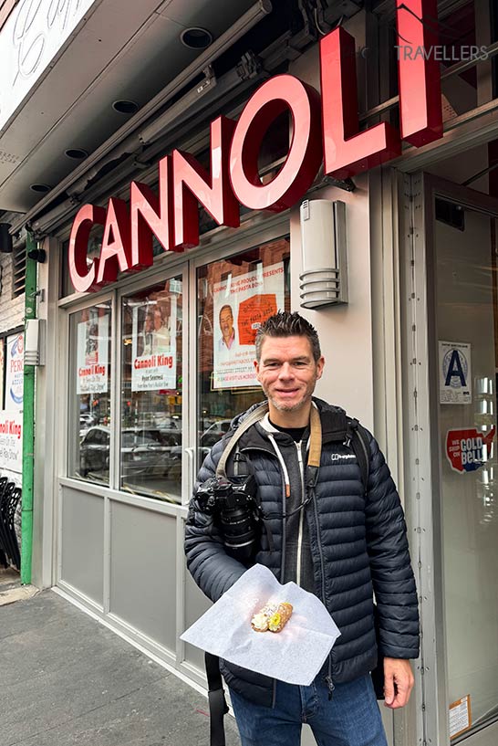 Reiseblogger Florian Westermann vor dem Caffé Palermo in New York mit zwei Cannoli