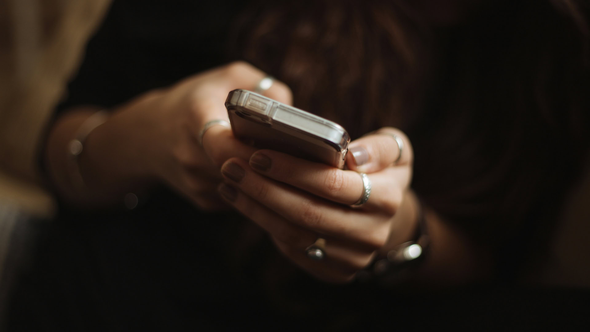 Im Fokus sind, zwei Hände die ein Handy halten.