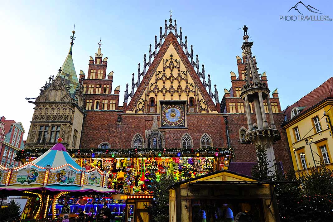 Vor dem Alten Rathaus mit seinen Türmen und Spitzgiebeln sind farbenfrohe Marktstände aufgebaut