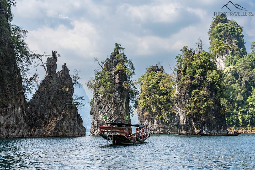 Ein Boot vor den drei Felsnadeln "Hin Sam Glur" im Cheow-Lan-Lake im Khao Sok Nationalpark