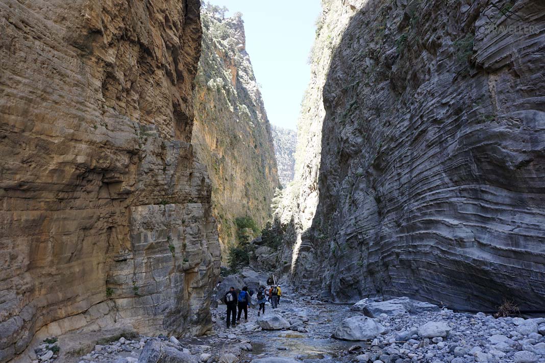 Eine größere Wandergruppe zwischen hohen Felswänden in der Samaria-Schlucht
