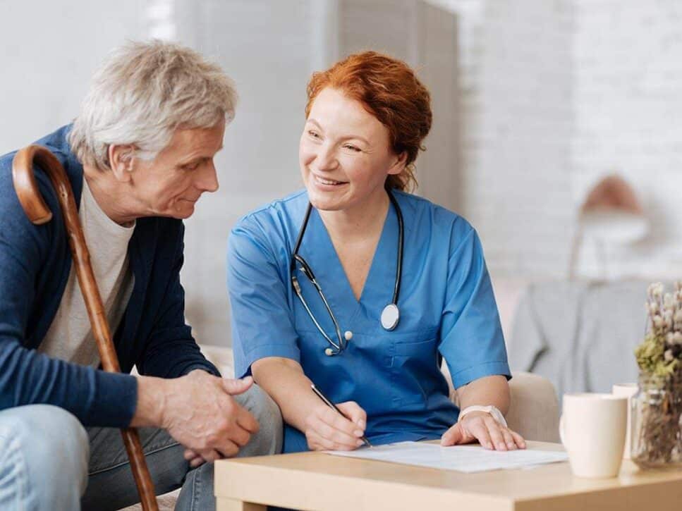 home-care-services-assistance Friendly home care nurse assisting a senior man with personalized care services.