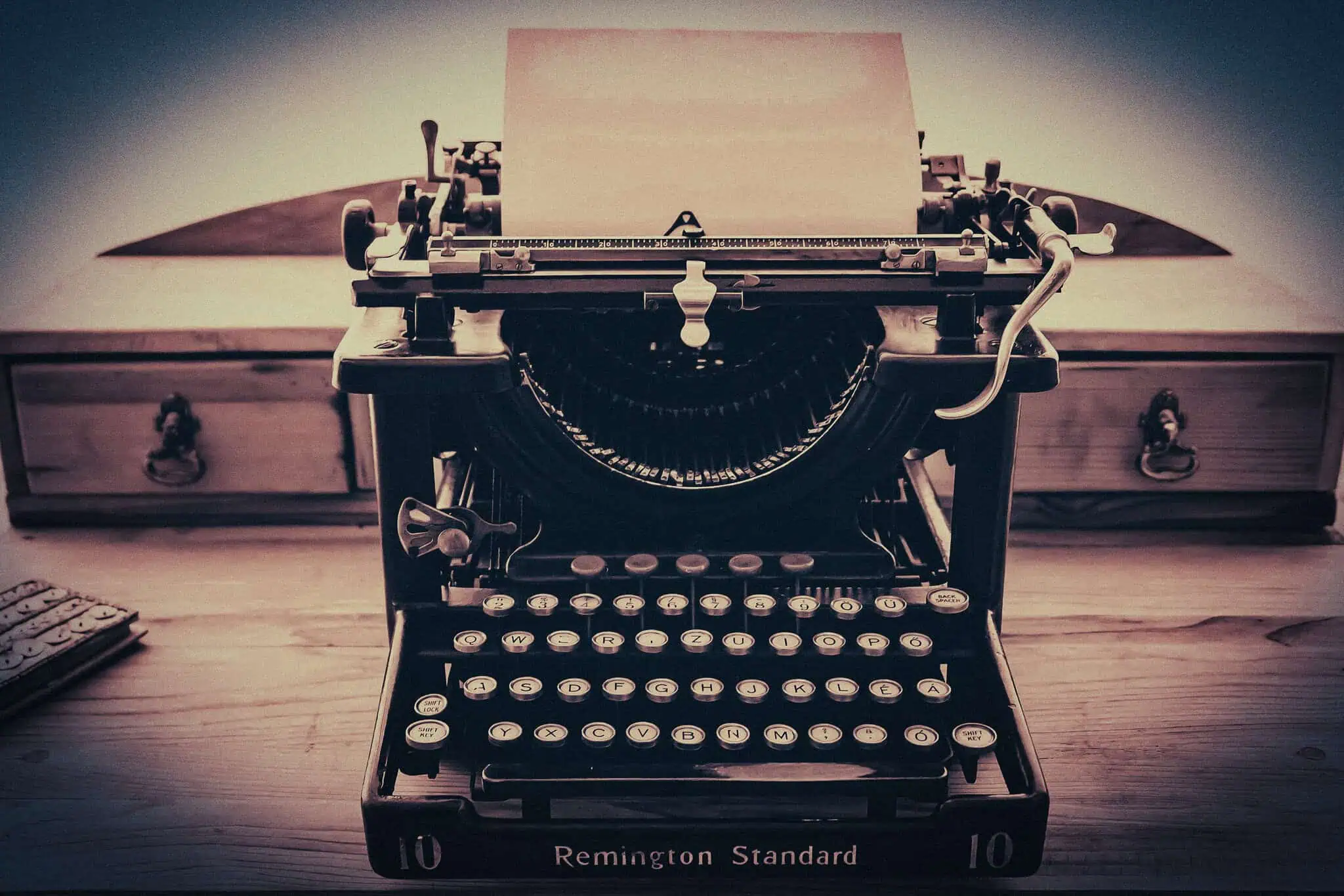 Erotophonophilia. Vintage Remington typewriter on a wooden desk with paper ready for typing.