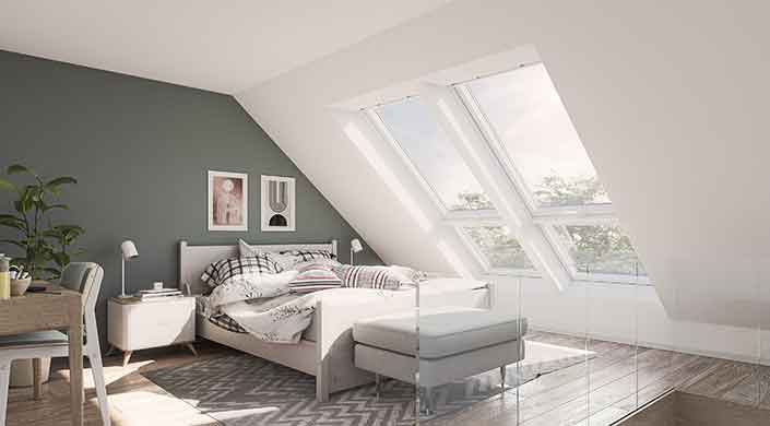 Helles Schlafzimmer mit Dachfenster, einem Bett mit gestreifter Bettwäsche und einem Nachttisch.