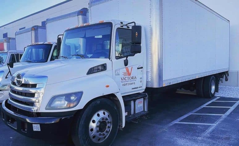 Victoria Transport Service straight trucks backed up to the warehouse dock {{brizy_dc_image_alt imageSrc=