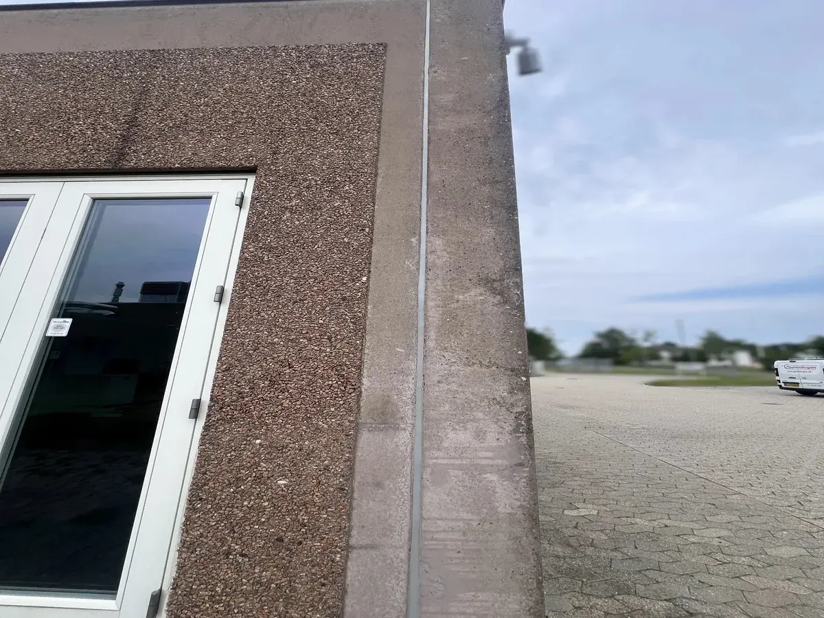 Professionel fugning af sandwichelementer med søstensfacade og beton i industribyggeri.