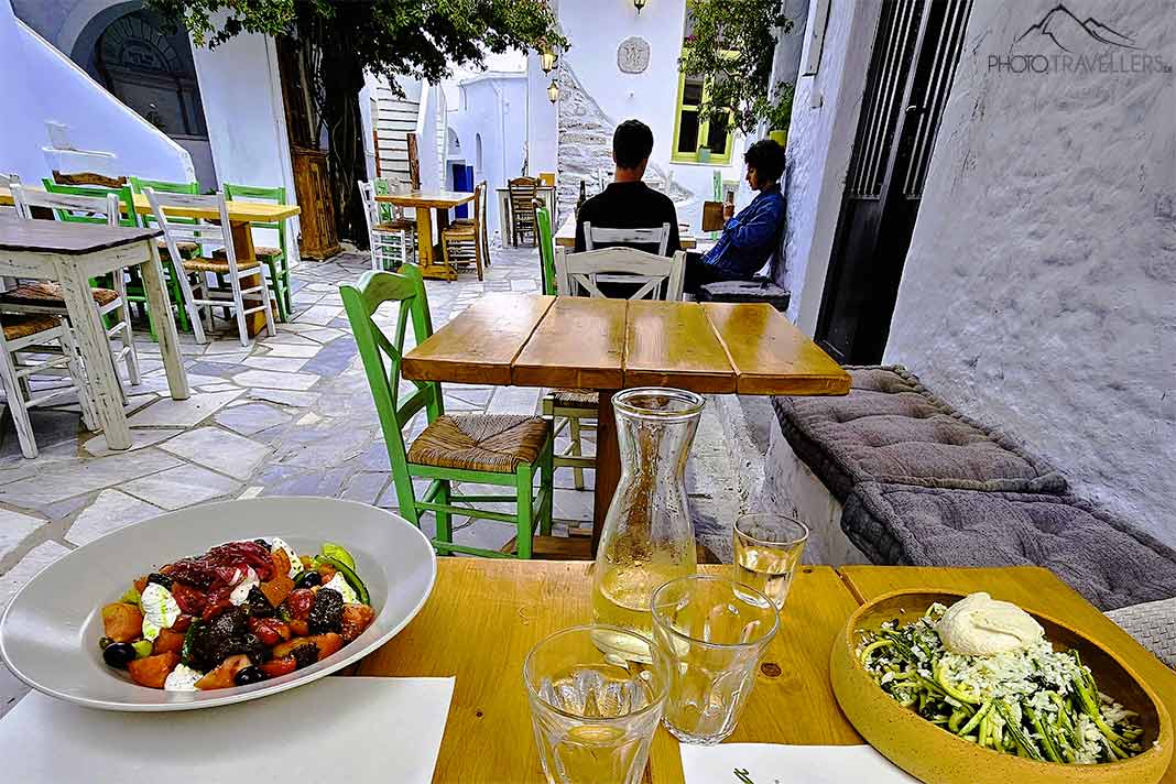 Zwei Teller mit griechischen Speisen stehen auf den Tischen einer Taverne in Kampos