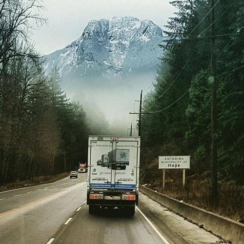 Truck driving towards snowy mountain in Hope, Canada.