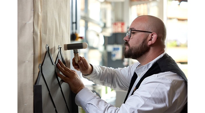 Ein Mann im weißen Hemd arbeitet mit elektronischen Geräten in einem modernen Laborumfeld.