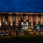 Ein Foto der Gebläsehalle von außen bei Nacht. Menschen strömen durch den Eingang.