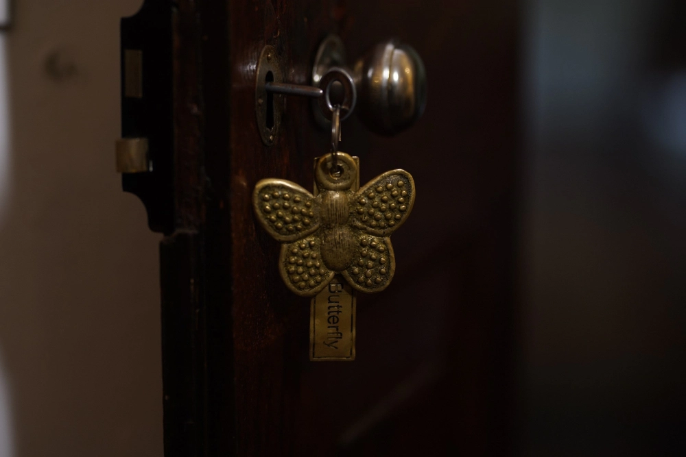 A decorative key featuring a butterfly, symbolizing the Lime Butterfly room at Adigar's Manor.