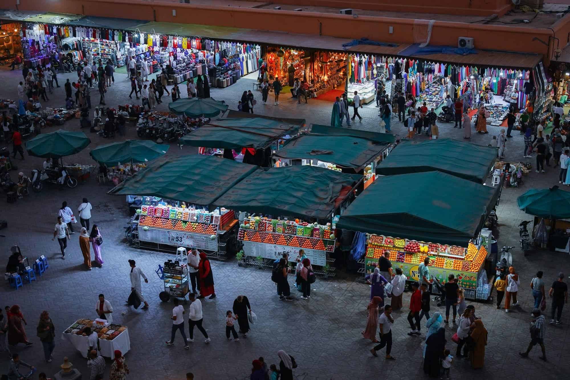Mercado nocturno en Marrakech con puestos de artesanías y comida.