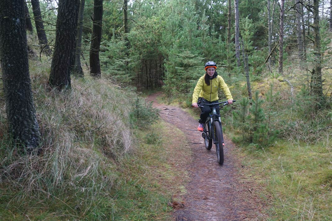 Reisebloggerin Biggi Bauer auf einem Fatbike auf einem Singletrail im Wald in der Jammerbucht-Region