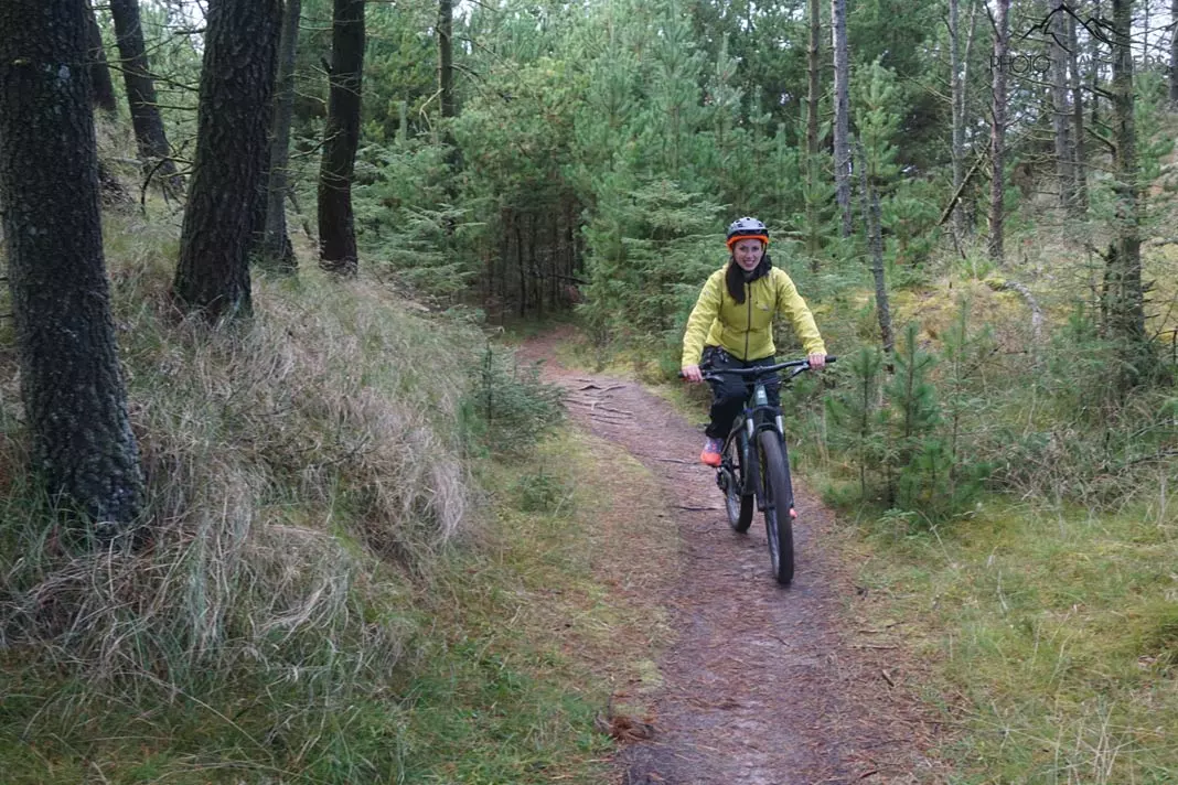Reisejournalistin Biggi Bauer auf einem Fatbike auf einem Single-Trail im Wald in Dänemark