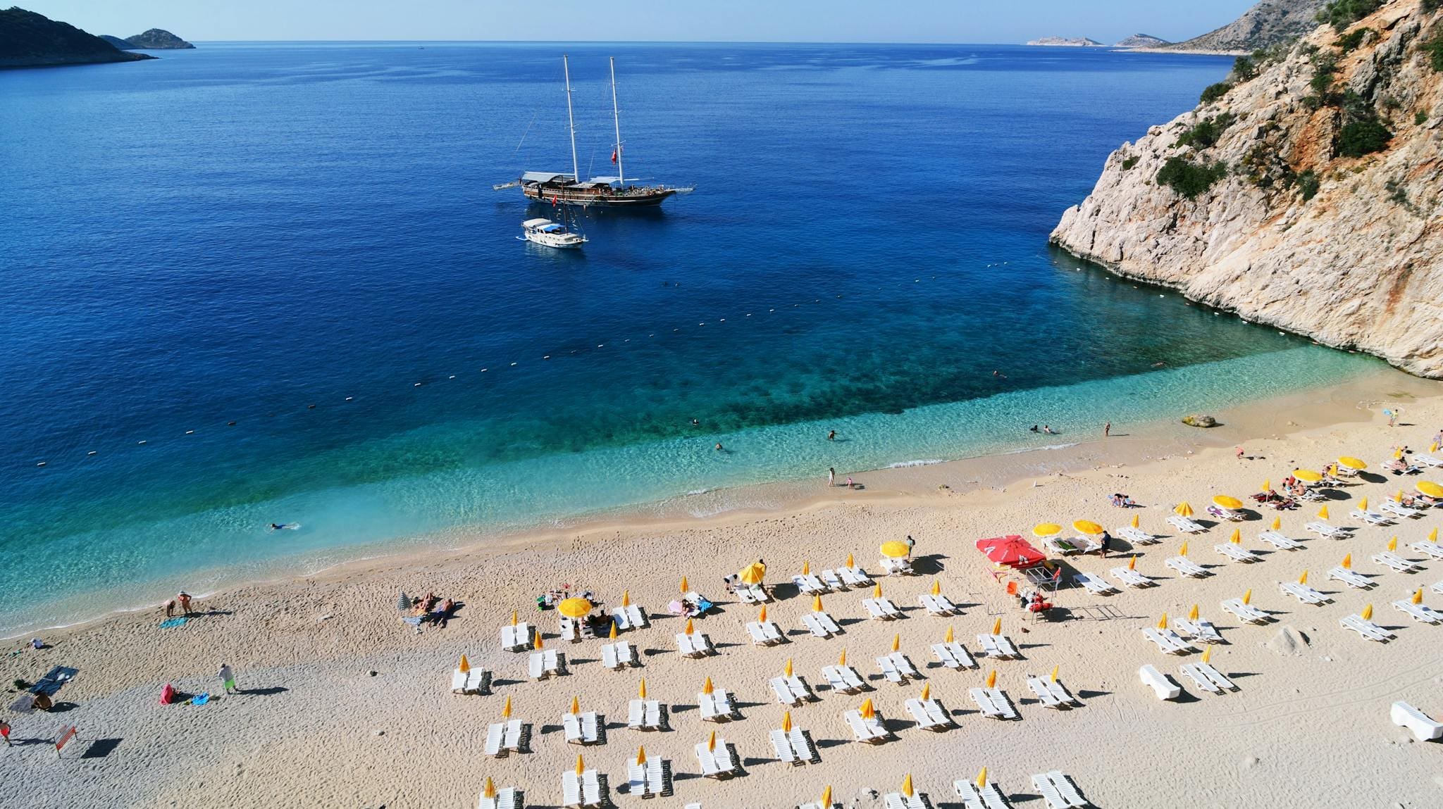 Aerial view of Kaputas Beach in Antalya, Türkiye, showcasing turquoise waters and sunbathers.