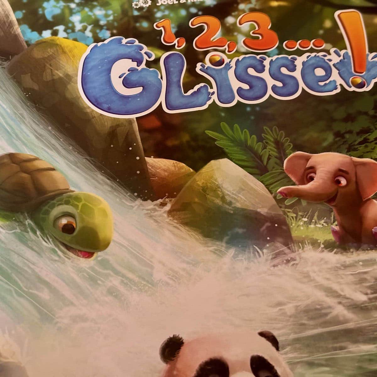 Fun enfant jouant avec le jeu de glisse pour enfants de 1 à 5-9 ans, avec des animaux de la jungle, un éléphant et une tortue, sur un décor coloré de forêt tropicale, idéal pour les jeunes enfants.
