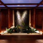 A living room filled with furniture and vase of flowers on a wooden table