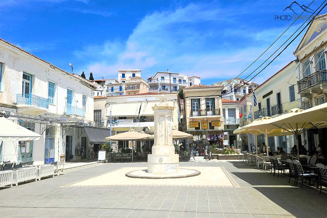 Der alte weiße Brunnen auf der Plateia Spirou Karamanou ist umgebung von vielen kleinen Häusern