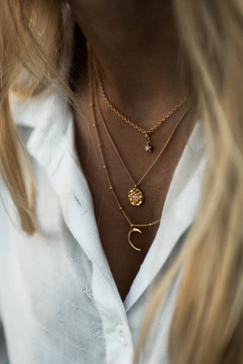 Chic Jewellery Styles For 2021 Woman in White Blouse Wearing Multiple Delicate Necklaces