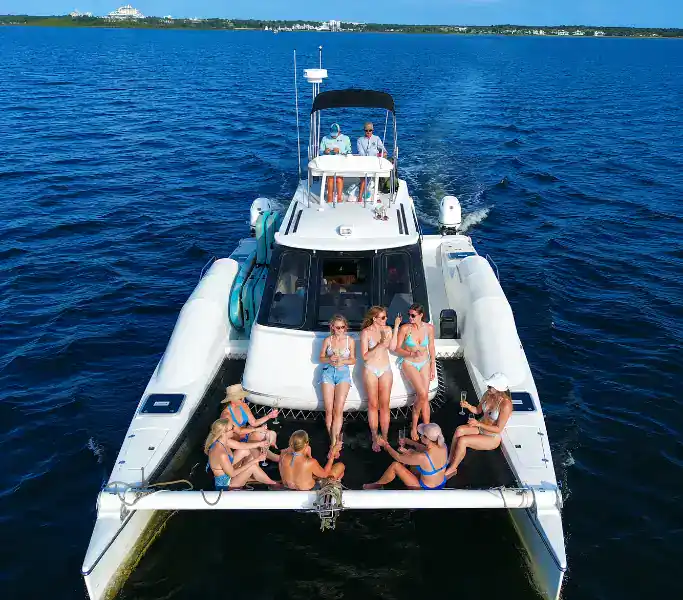 Girls riding on the front of a Catamaran headed for Crab Island with Crab Island Luxury Adventures