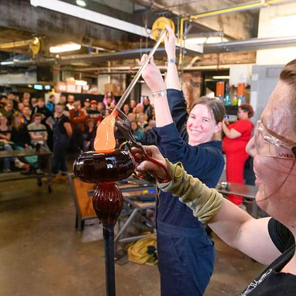 Glass artists doing a glassblowing demonstration at Pittsburgh Glass Center