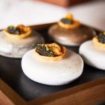 A wooden cutting board with a cake on a plate