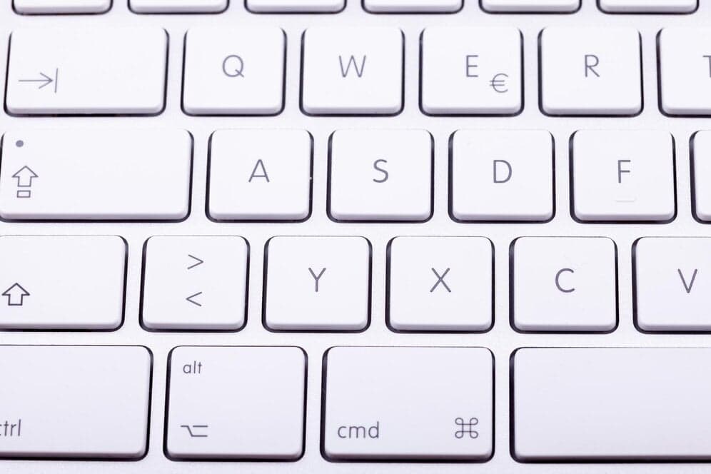 Close-up of a white computer keyboard showing letter keys, symbols, and command keys