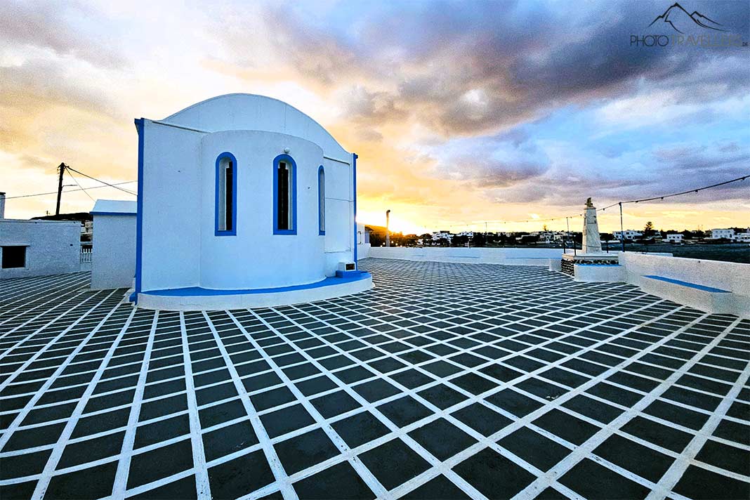 Die kleine weiße Kapelle von Pollonia im Abendlicht mit grau-weißem Bodenbelag