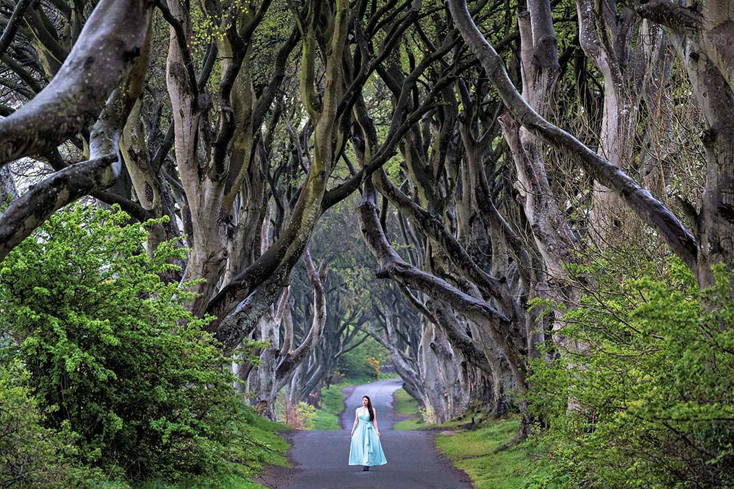 Reisebloggerin Biggi Bauer in einem blauen Kleid in den Dark Hedges in Nordirland