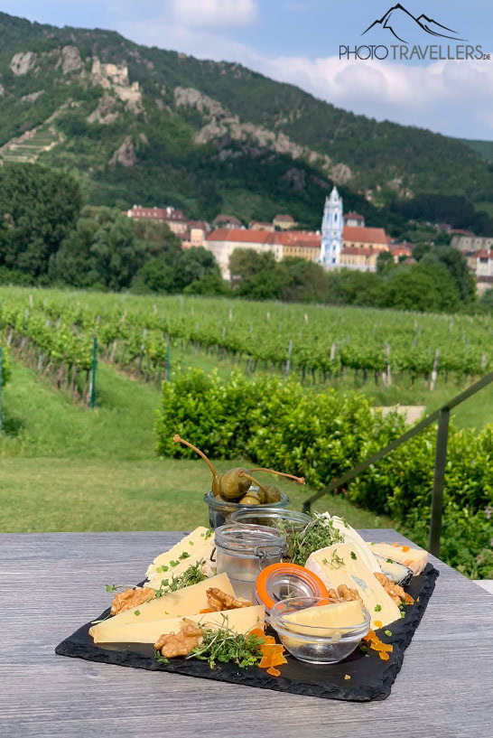 Eine Käseplatte in der Flößerei in Rossatz mit Blick auf den blauen Kirchturm in Dürnstein