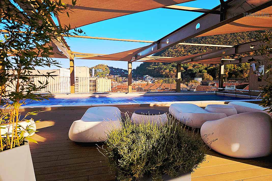 Ein halbüberdachter Pool und helle Liegepolster auf der Dachterrasse des Radisson Blue in Brasov