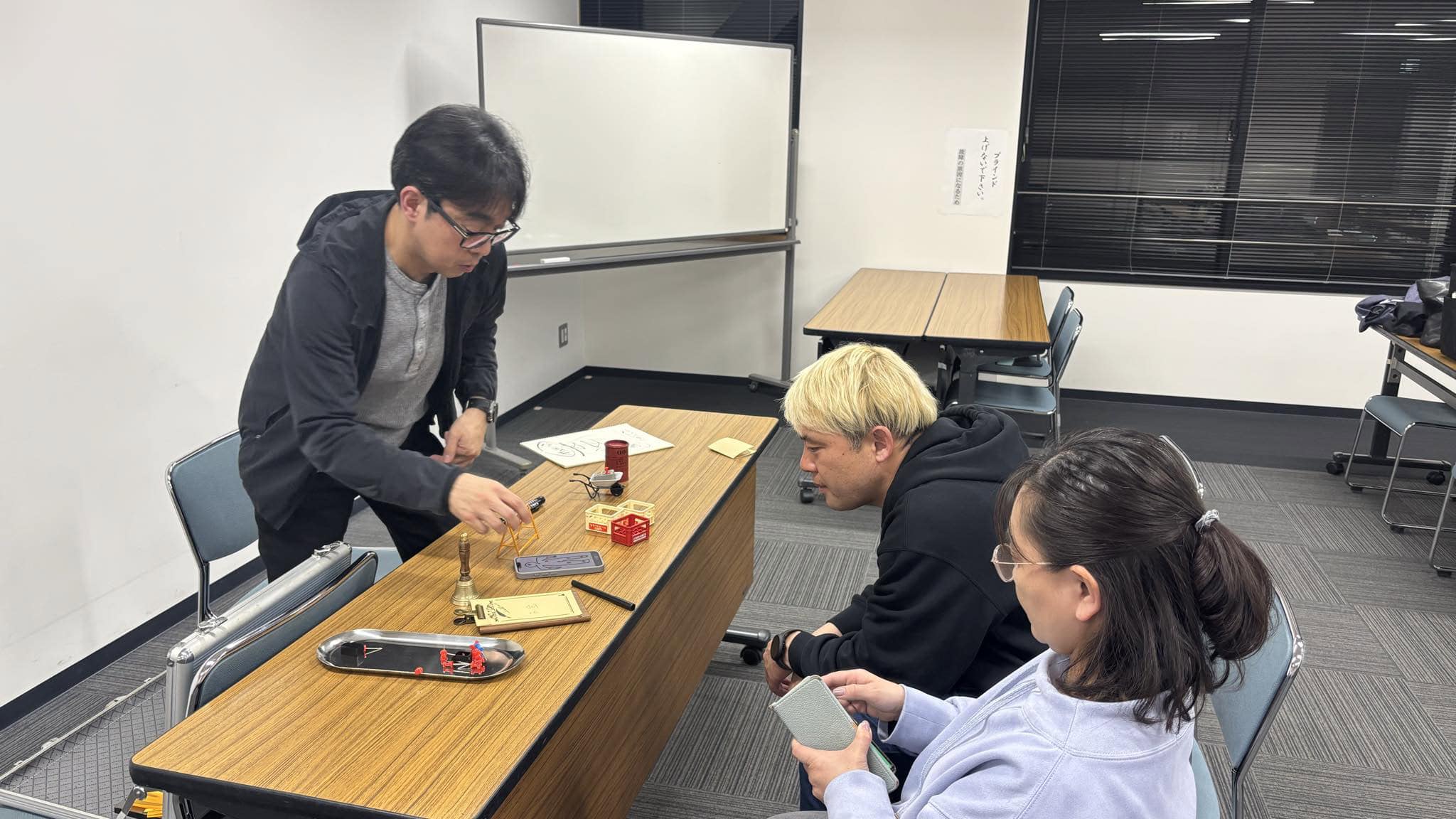 マジック研究会で3分間スピーチを導入!マジシャンが「言葉にする力」を鍛える理由|コンプオフィス 3 コンプオフィス マジック研究会 マジック道具を使ったディスカッションの様子