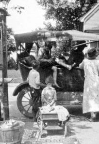 1920s pop stand Horse-drawn streetcar with passengers and street vendors in front, vintage transportation history.
