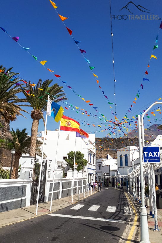 Blick auf eine Straße mit Wimpeln und weißen Fischerhäuschen in Agaete
