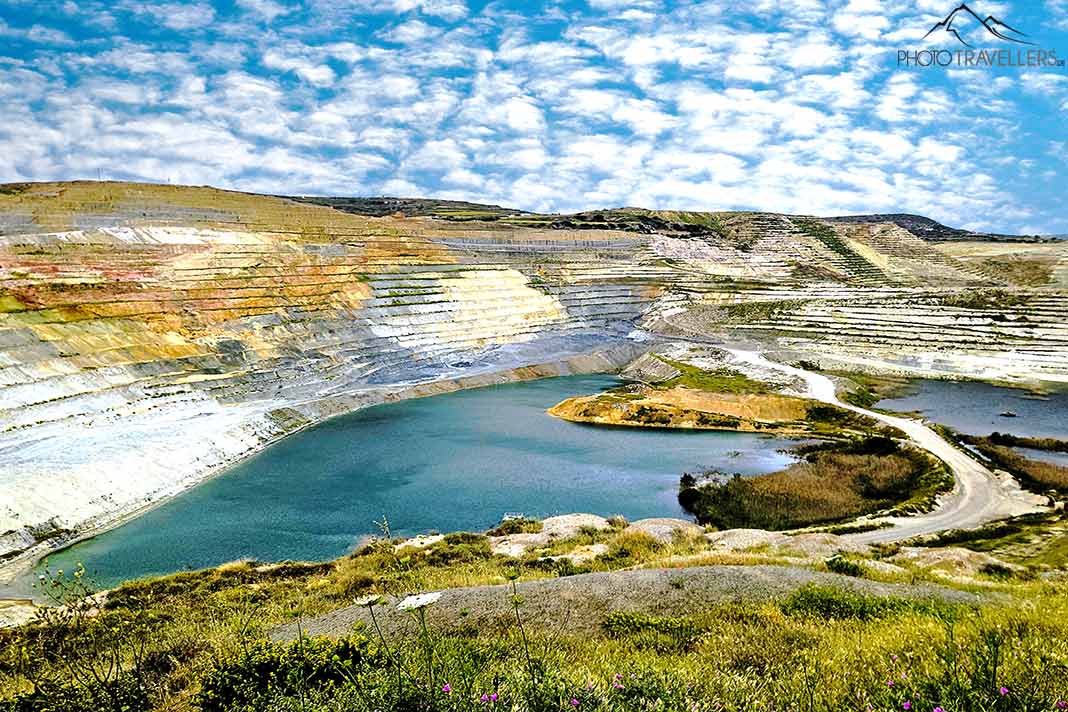 Die Aggeria-Mine mit unterschiedlichen Gesteinsschichten und einem See in der Mitte