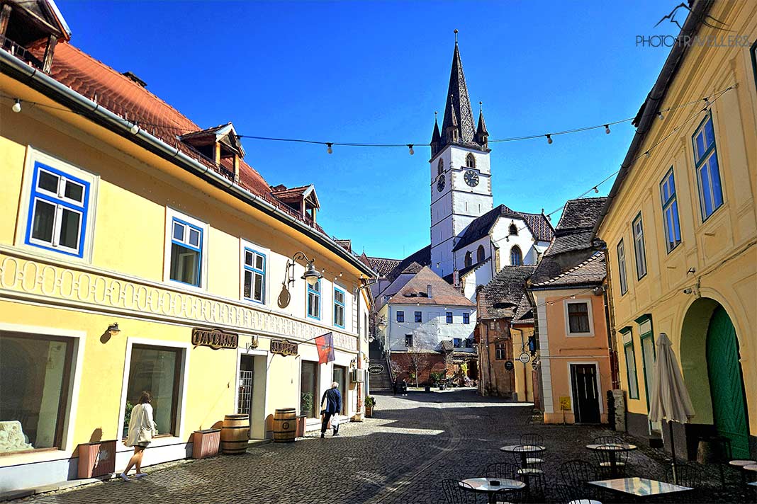 Gelbe Häuserfassade umgeben die Gassen der Unterstadt von Sibiu mit Blick auf die Marienkirche