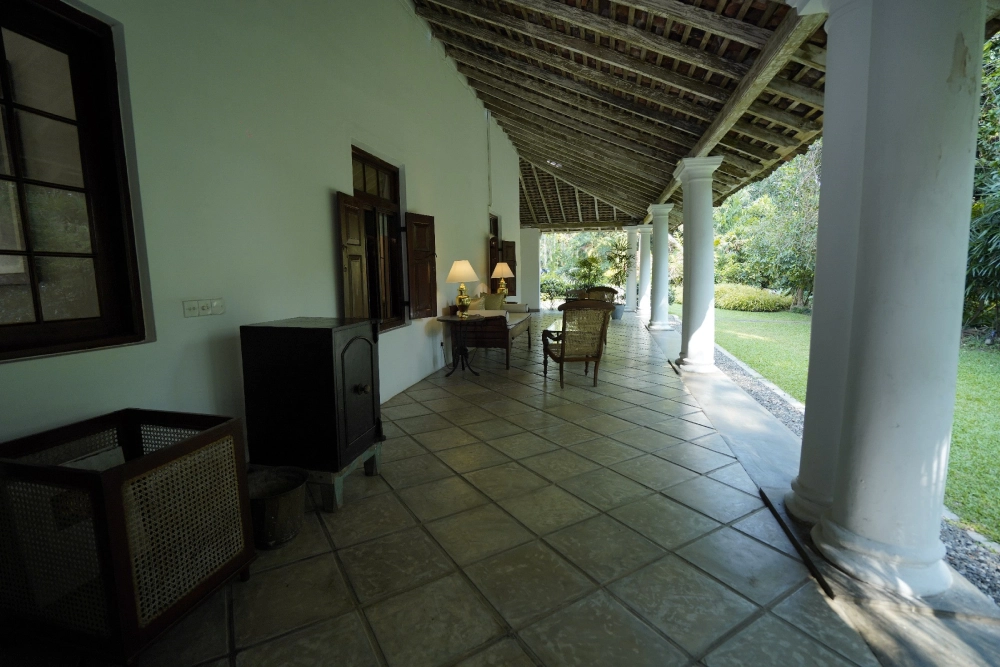 A porch in Adigar's Manor featuring a table and chairs, outside the red spot Duke room.
