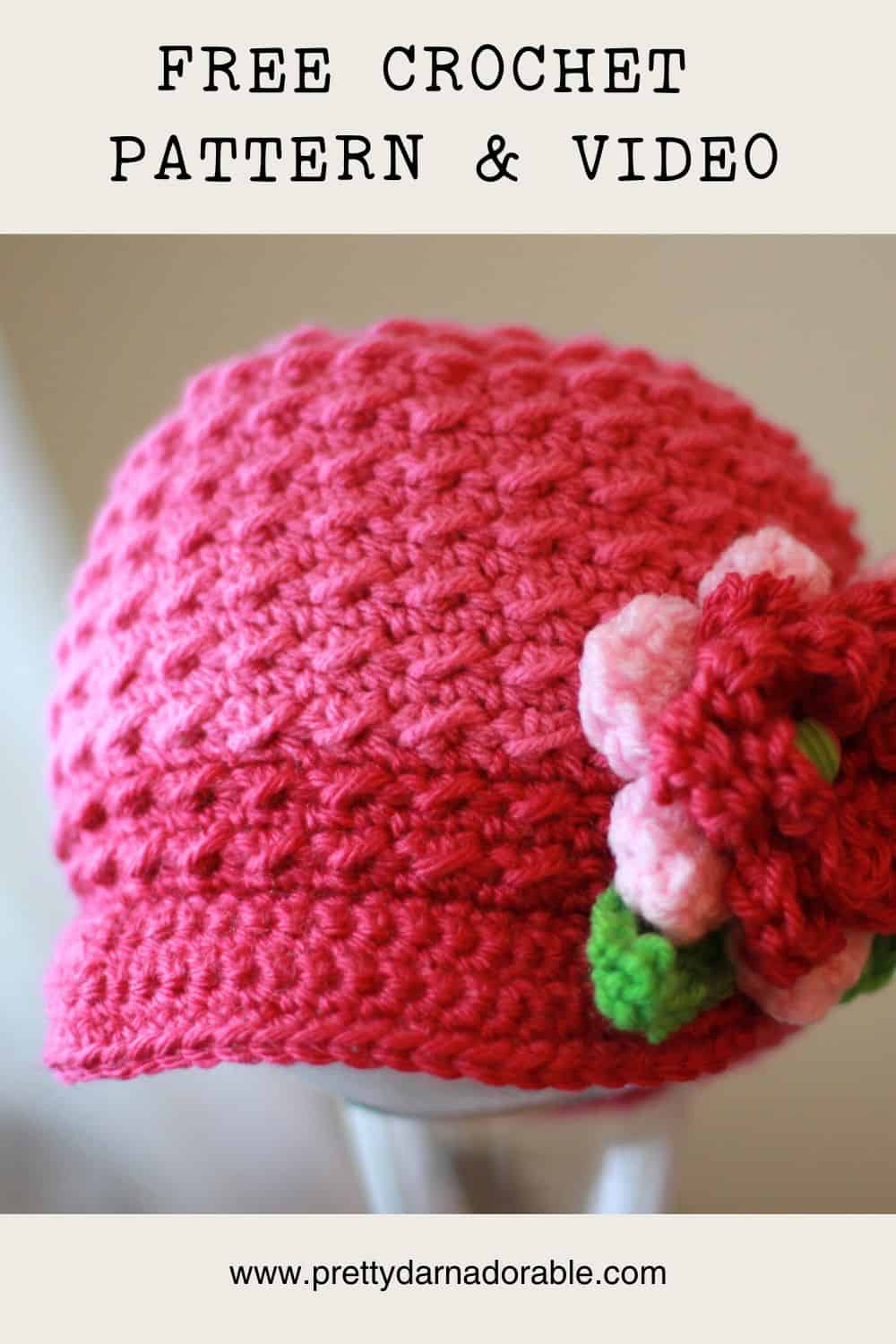 a crocheted pink newsboy cap hat with a flower on it