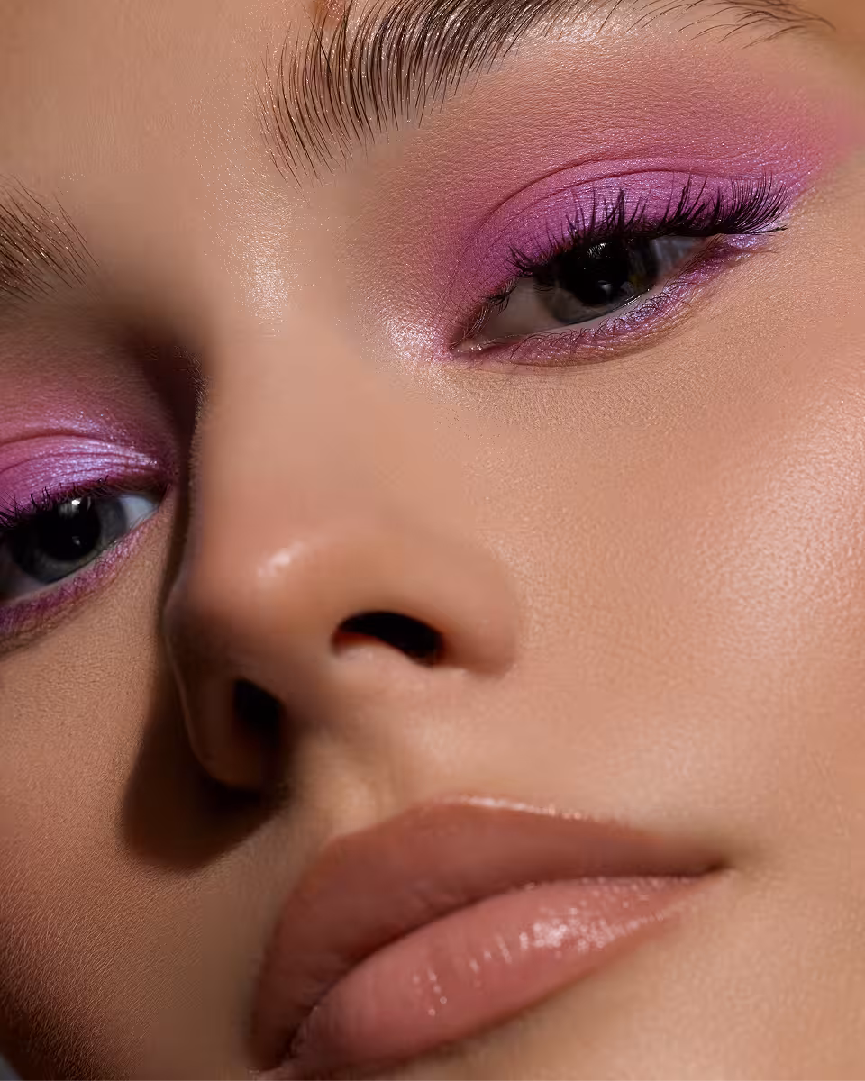 Nahaufnahme eines geschminkten Gesichts mit hellrosa Lidschatten und nudefarbenem Lippenstift