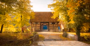 Hochzeitslocation Haus Runde 1 Backsteinscheune mit rotem Ziegeldach und blauen Türen – ein idealer Hochzeitsort für eine Freie Trauung in Münster Umgebung.