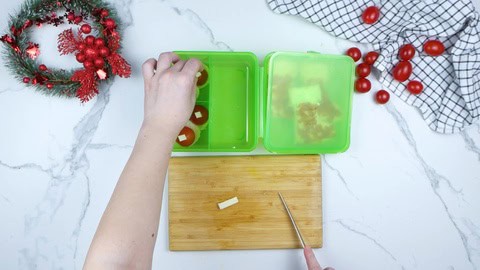 Nikolaus Mützchen aus Tomaten in die Lunchbox geben