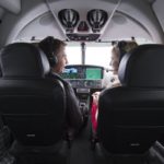 A group of people sitting around a car