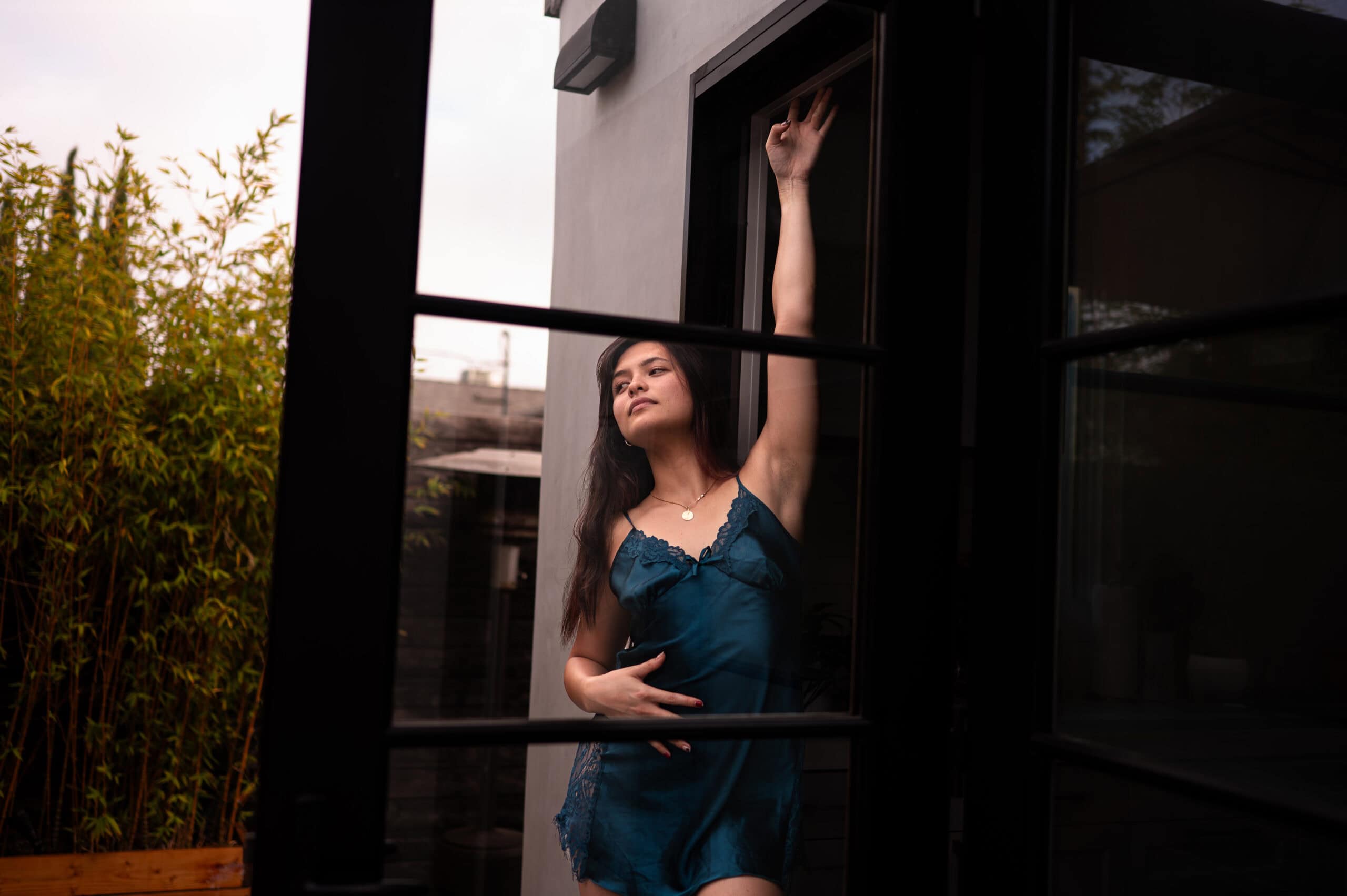 Is boudoir photography worth the investment? This photograph is of a boudoir client posing against a doorway.