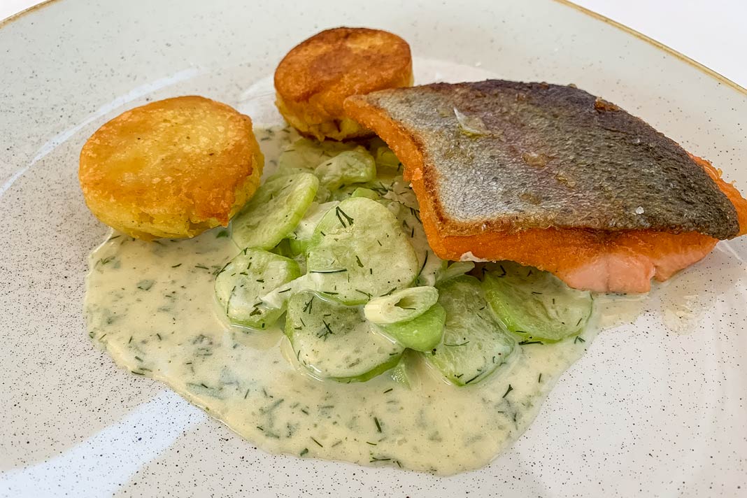 Ein Teller mit Fisch, Gurkensalat und Kartoffelbratlingen im Gasthof zum Kaiser von Österreich in Krems