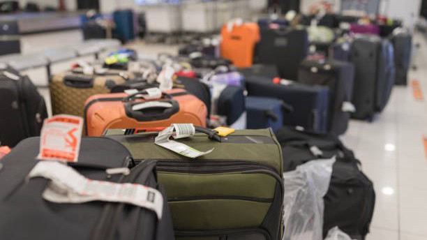 Briefcases waiting on a luggage rack for the travelers to pick them up