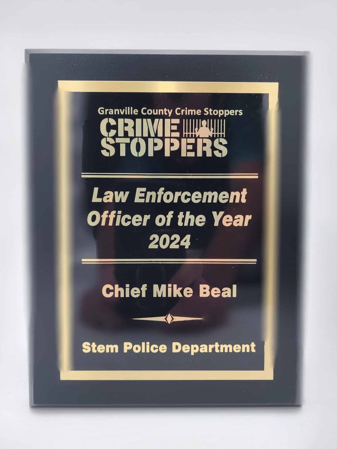 A plaque recognizing Chief Mike Beal as the Law Enforcement Officer of the Year 2024, awarded by Granville County Crime Stoppers to the Stem Police Department.