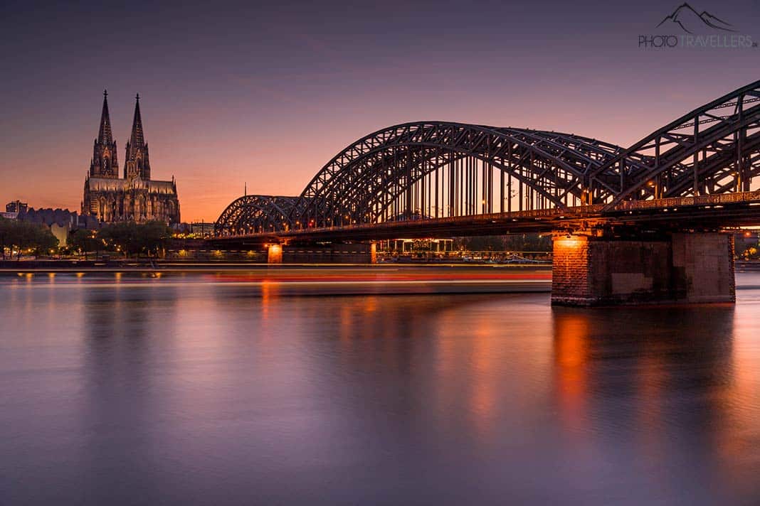 Der Kölner Dom mit der Hohenzollernbrücke im Dämmerlicht am Abend