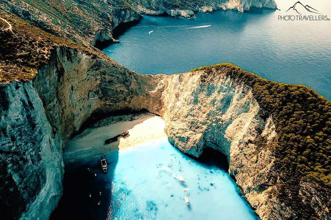 Das türkisblaue Meer bildet einen starken Kontrast zu den hellen Felsen und dem Sand am Navagio Beach
