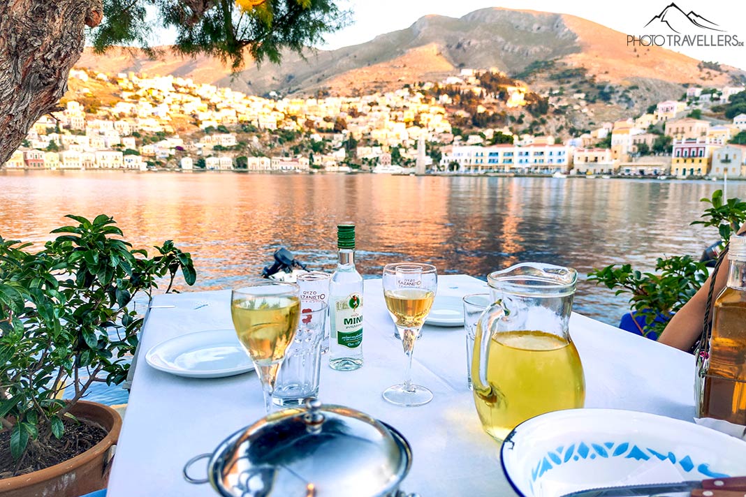 Gedeckter Tisch mit Weingläsern an der Bucht von Symi